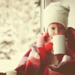 Little girl drinking by the window