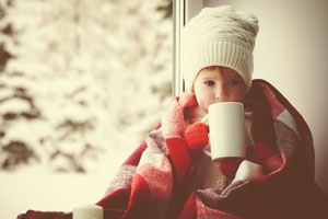 Little girl drinking by the window